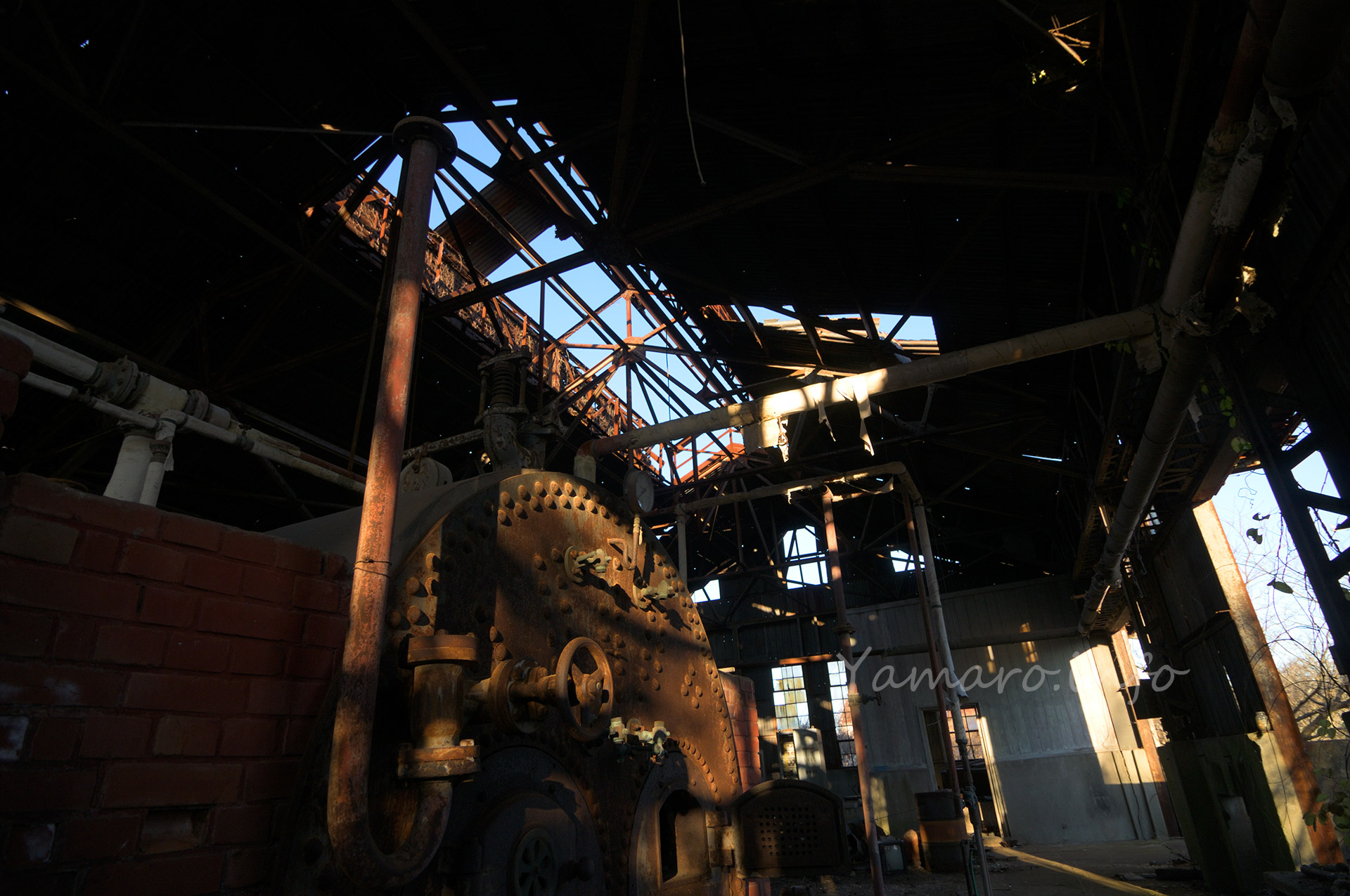 機罐場の屋根の一部はトタンが剥がれてなくなっている。中央は放熱のためか、意図的に屋根が開いていて、本来はその上にさらに屋根があって雨を避けていたが、そこの屋根のトタンは全てなくなっている 2011年でこんな感じだが、現在はどうなっているのか？